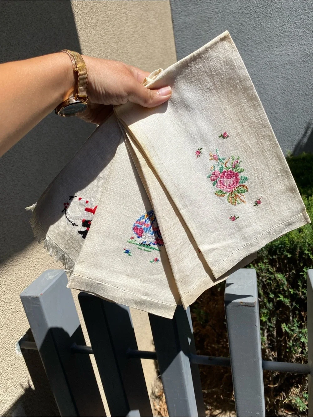 The image shows a set of four vintage hand-embroidered and cross-stitched